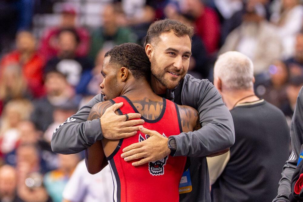 Redshirt freshman Vince Robinson hugs his coach during the NCAA Wrestling Championship Tournament in the Wells Fargo Center on Friday, March 21, 2025.