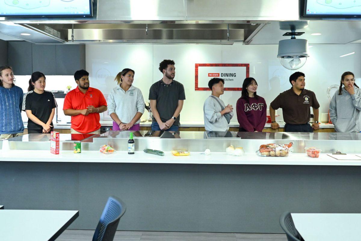 Both teams of students line up to hear what the secret ingredients of their challenge are during the MGC Chopped: Cooking Competiton at Carmichael Gym on Wednesday, March 26, 2025. The event was organized by members of the Multicultural Greek Council.