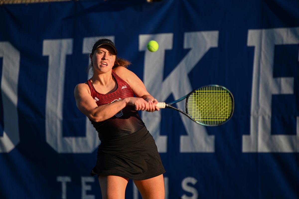 Junior Anna Zyryanova winces backhands the ball during the match against Duke at Ambler Tennis Stadium on Friday, March 21, 2025. Zyryanova won her singles match 2-1. NC State fell to Duke 3-4.