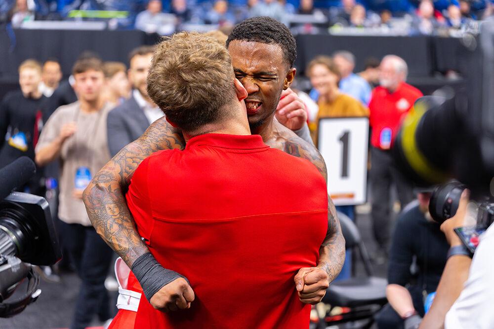 Redshirt freshman Vince Robinson embraces former wrestler Trent Hidlay after winning the 125 pound championship bout during the NCAA Wrestling Championship Tournament in the Wells Fargo Center on Saturday, March 22, 2025. NC State placed eighth overall with 46.5 points.