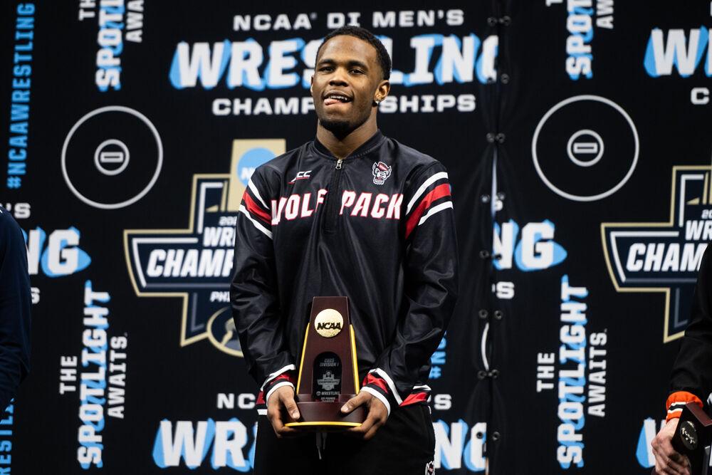 Redshirt freshman Vince Robinson celebrates on the podium after winning the 125 pound championship during the NCAA Wrestling Championship Tournament in the Wells Fargo Center on Saturday, March 22, 2025. NC State placed eighth with 46.5 points.