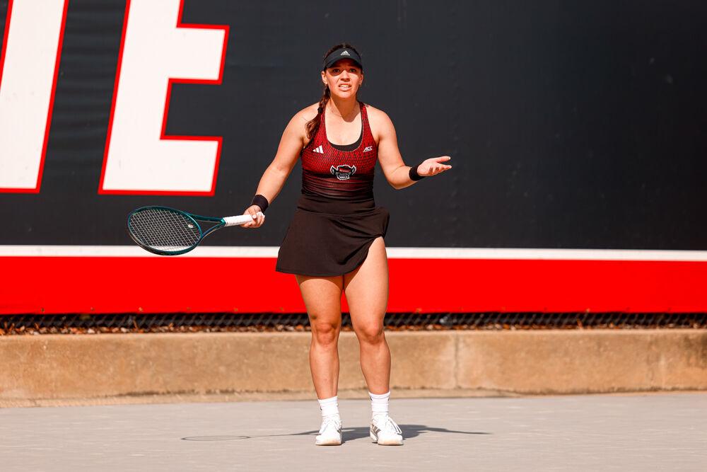 Freshman Michaela Laki puts her hand up in confusion after her opponent conceded the point during her singles game against Clemson at J.W. Isenhour Tennis Center on Friday, March 28, 2025. Laki won her singles match 6-4, 4-3. NC State won the match 4-0.