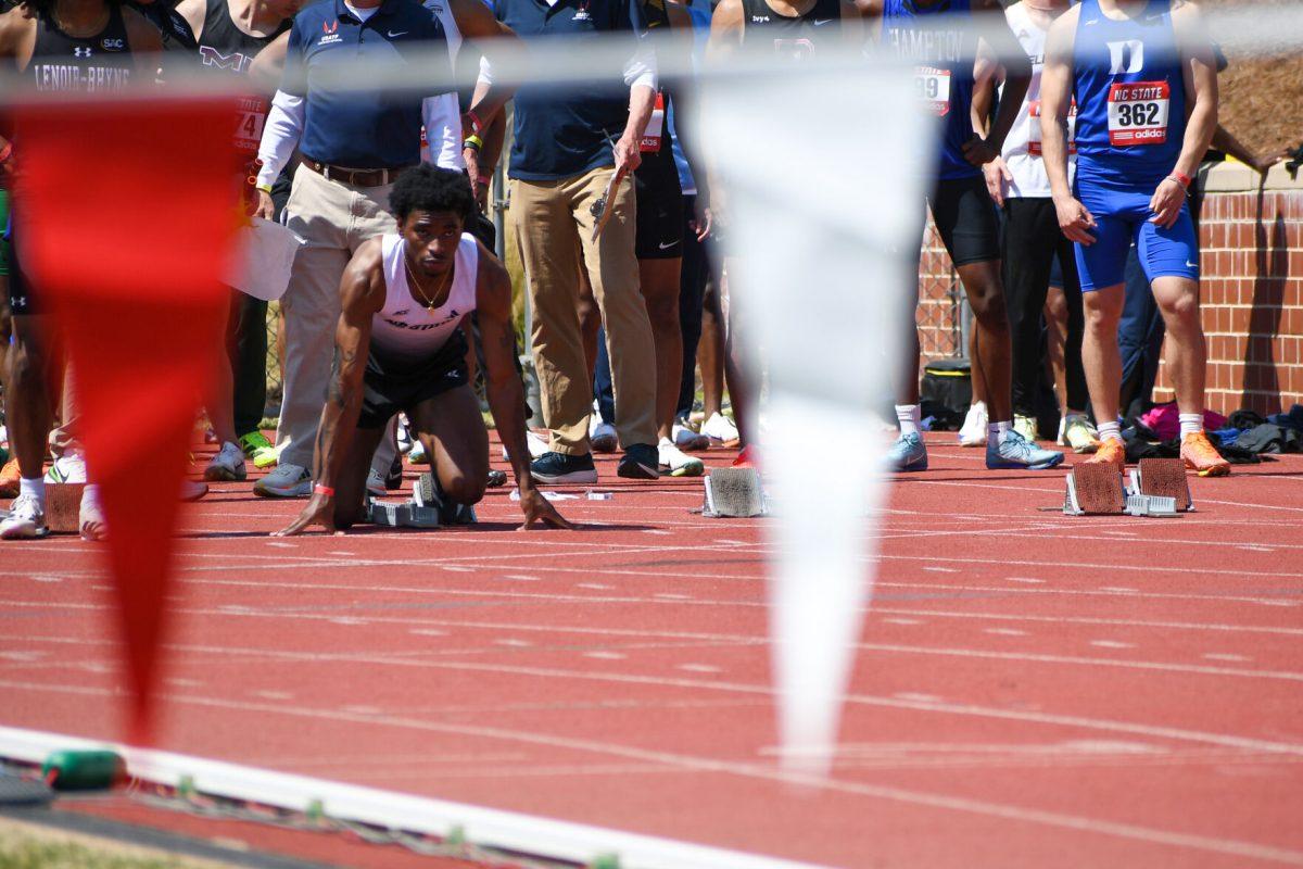 Freshman sprinter Brandon Harris gets set for the 100m during the Raleigh Relays track meet at the Derr Track and Field Facility on Friday, March 28, 2025. Harris finished second in his heat of the men's 100m with a time of 10.86.