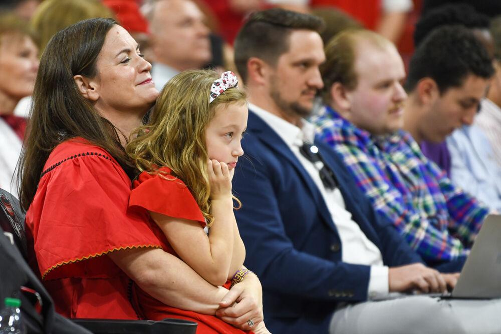 Lauren Wade, wife of new men's basketball coach Will Wade, holds her daughter Caroline during a press conference discussing the hiring of her husband inside Reynolds Coliseum on Tuesday, March 25, 2025. Wade will serve as the new men's basketball coach after having been at McNeese State.