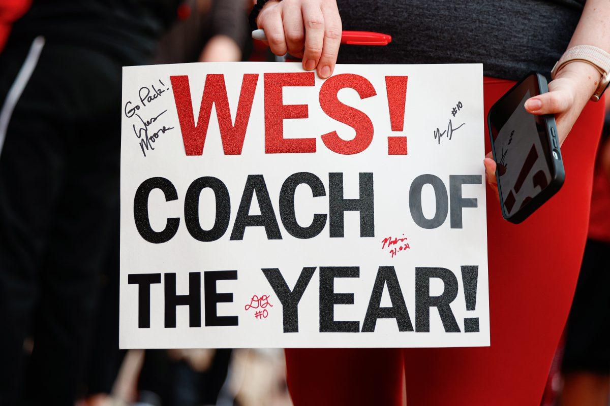 A fan holds up a "Coach of the Year" sign for the head coach Wes Moore during the team's welcome back to Reynolds Coliseum on Saturday, March 29, 2025. Moore is a Naismith Coach of the Year semifinalist.