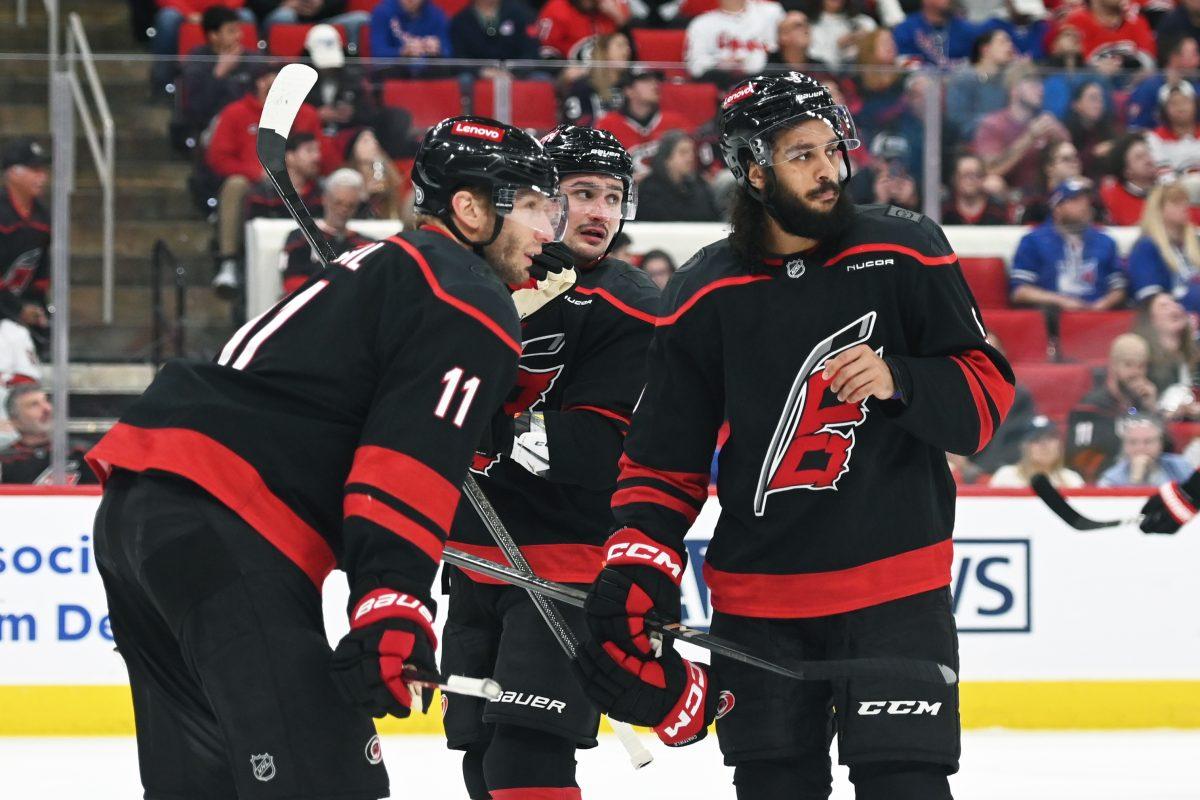 Center Jordan Staal and defensemen Dmitry Orlov and Jalen Chatfield talk during a break in the game versus the New York Rangers at the Lenovo Center on Saturday, April 12, 2025. Staal scored one goal for the Hurricanes. Chatfield scored one goal for the Hurricanes. The Hurricanes beat the Rangers 7-3.