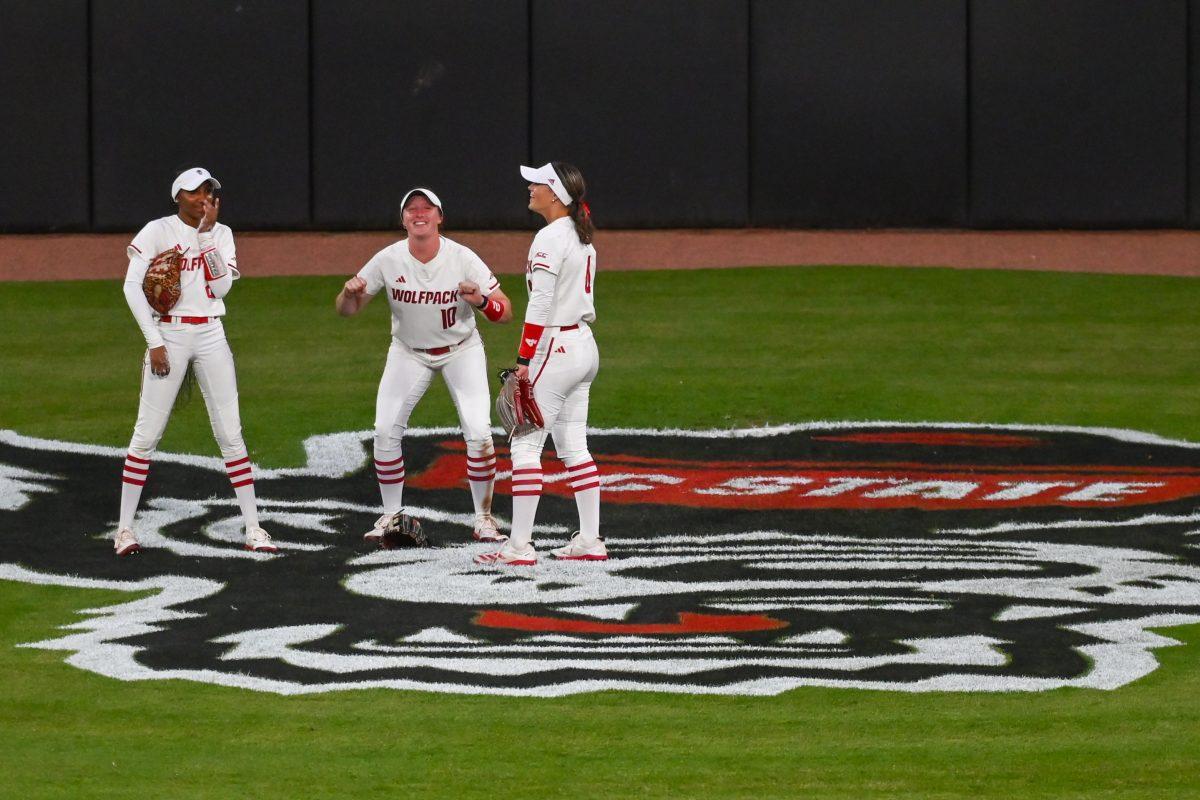 Junior outfielder Ellie Goins (center) mimics lifting weights during the game against Virginia Tech at Dail Softball Stadium on Friday, April 5, 2025. Goins walked her one time at bat. The Wolfpack lost to the Hokies 10-2.