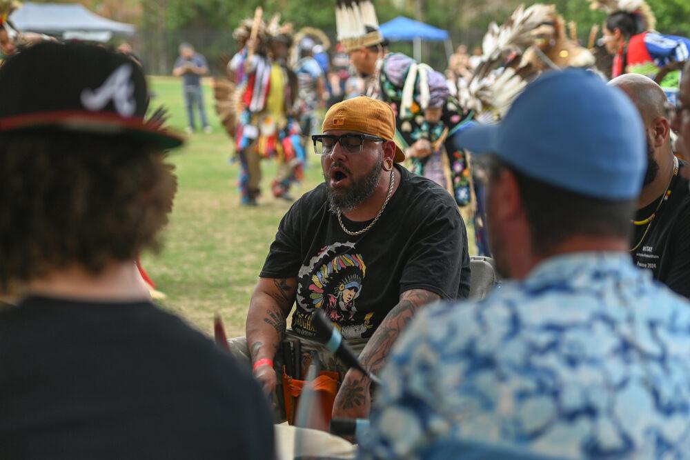 A member of a traditional Native drum group sings and plays the drum to accompany the performance behind him during NC State's 35th Annual Powwow at Miller Fields on Saturday, April 5, 2025. The event, sponsored by the Multicultural Student Association, highlighted various Native tribal nations through a display of different Indigenous dance styles and traditional drum groups.