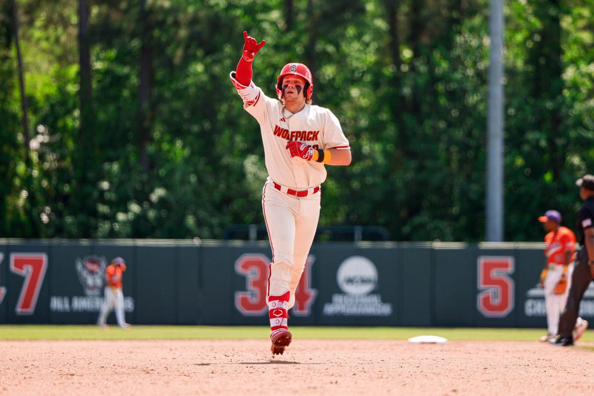 Sophomore catcher Alex Sosa holds up the "wolfie" sign during the annual "Victory over Cancer" game at Doak Field at Dail Park on Sunday, April, 27, 2025. Sosa hit two homers during the series versus Clemson. NC State beat Clemson 4-1.