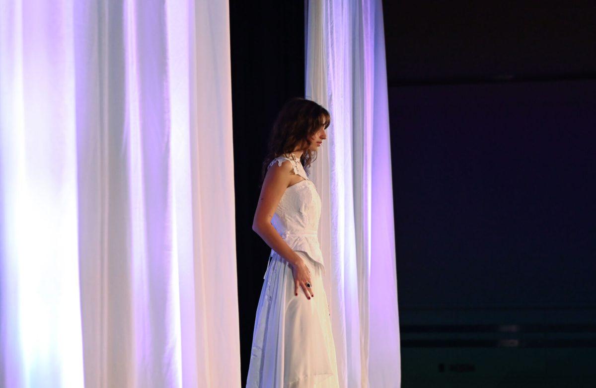 A model stands at the top of the runway in a piece designed by Grace Chen, a second-year studying fashion and textile design, as part of her collection, "In the Midst Of," during the 27th Annual Fashion Expose at Talley Student Union on Thursday, April 10, 2025. Students showcased their hard work from the semester in front of a panel of judges.