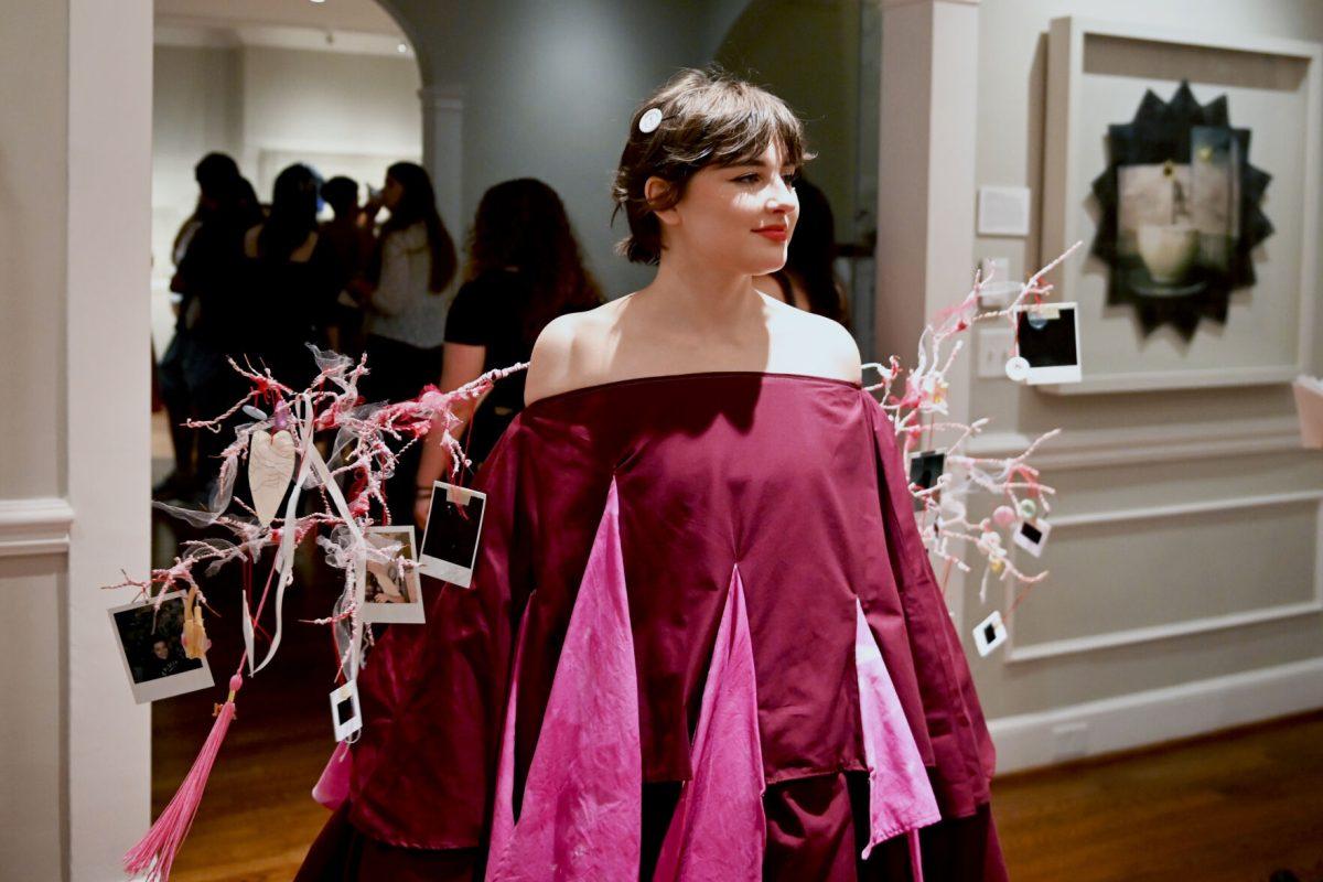 Sophie Dickerson, a fourth-year studying graphic and experience design, walks around while modeling her piece &#8220;Ornaments of Being&#8221; during the Art2Wear: Revive! show at the Gregg Museum of Art and Design on Thursday, April 24, 2025. Dickerson&#8217;s piece uses neuron branches decorated with childhood photos and memorabilia to revive memories of her past.