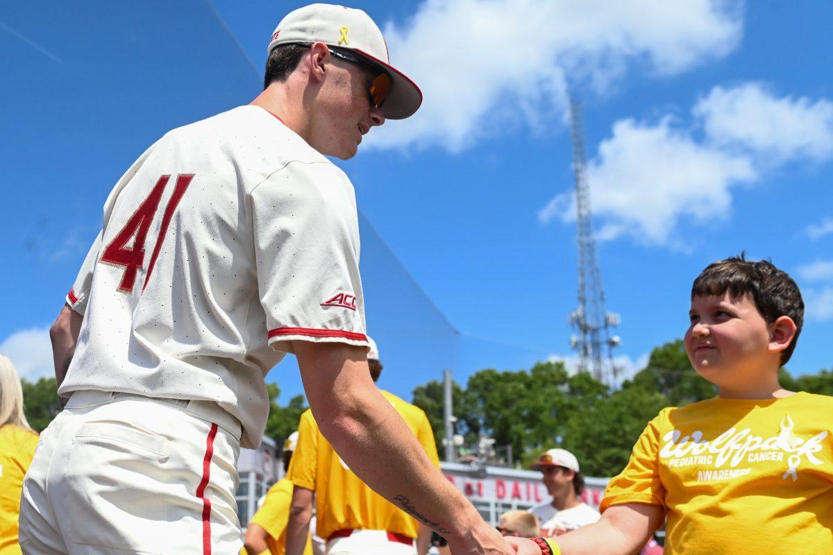 Sophomore right-handed pitcher Jacob Dudan shakes hands with cancer survivor Isaac Sloans before the game against Clemson at Doak Field at Dail Park&#160;on Saturday, April 26, 2025. Dudan recorded his fifth save of the season. NC State beat Clemson 4-1.