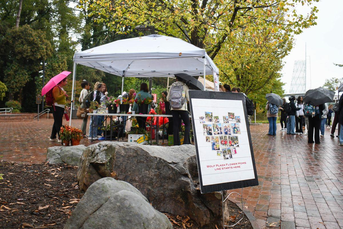 A sign points students towards the Flower Moms tent at Wolf Plaza on Thursday, Nov. 14, 2024. The Free Moms engage with students every Thursday, chatting with them and giving out a variety of free goods.
