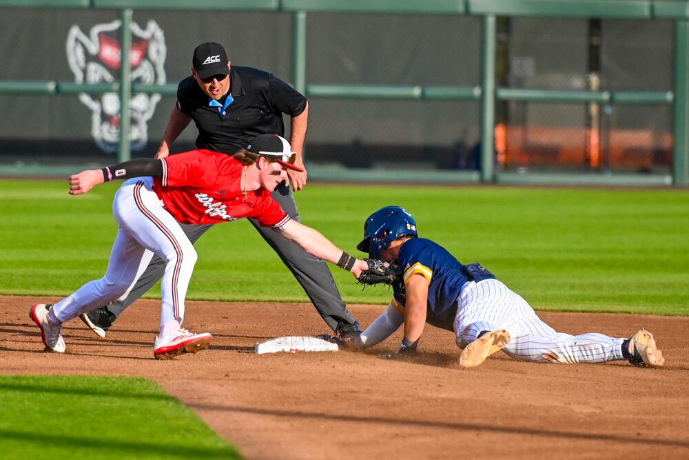 Sophomore infielder Luke Nixon attempts to tag the runner out during the game against UNC-Greensboro on Doak Field at Dail Park on Tuesday, April 1, 2025. The Wolfpack defeated the Spartans 9-6.