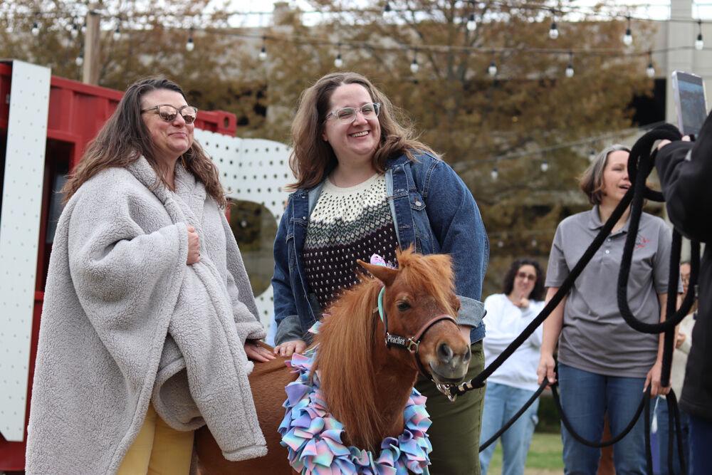 Wilson College of Textiles staff Alicia Lecceardone and Emily Richbourg take a photo with Peaches the Mini Horse at The Corner on Centennial Campus on Tuesday, April 8, 2025. Stampede of Love organization is a non-profit group dedicated to sharing the therapeutic benefits of animal therapy of adults and children.