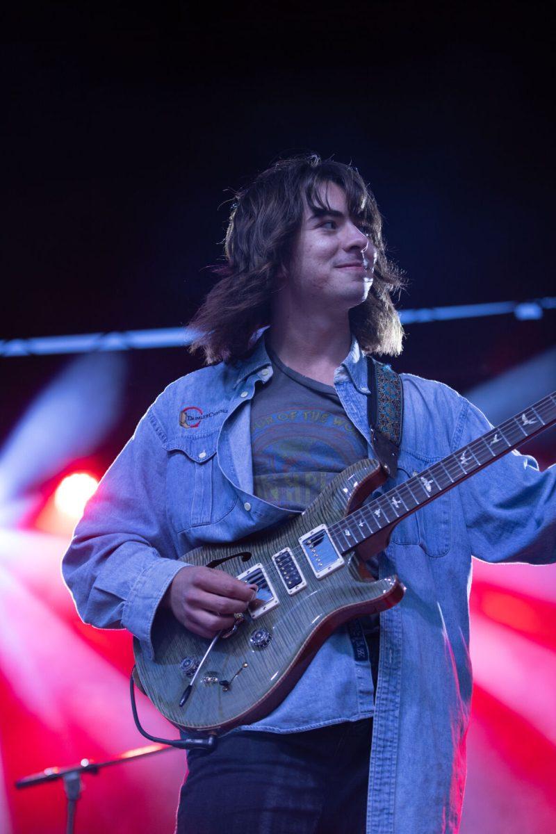 Pilot Light member Mason Stark smiles at his bandmates during Wolfstock on Miller Fields on Saturday, April 12, 2025. Pilot Light opened for indie band Peach Tree Rascals.