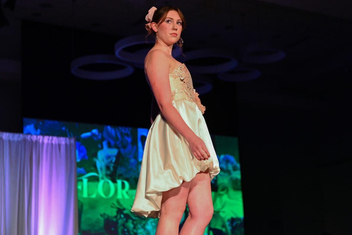 A model poses at the end of the runway wearing a piece from "Floraison," a collection designed by Brianna Anderson, a second-year studying fashion and textile design, during the 27th Annual Fashion Expose at Talley Student Union on Thursday, April 10, 2025. Anderson, one of the winning novice designers, drew inspiration from florals and spring.