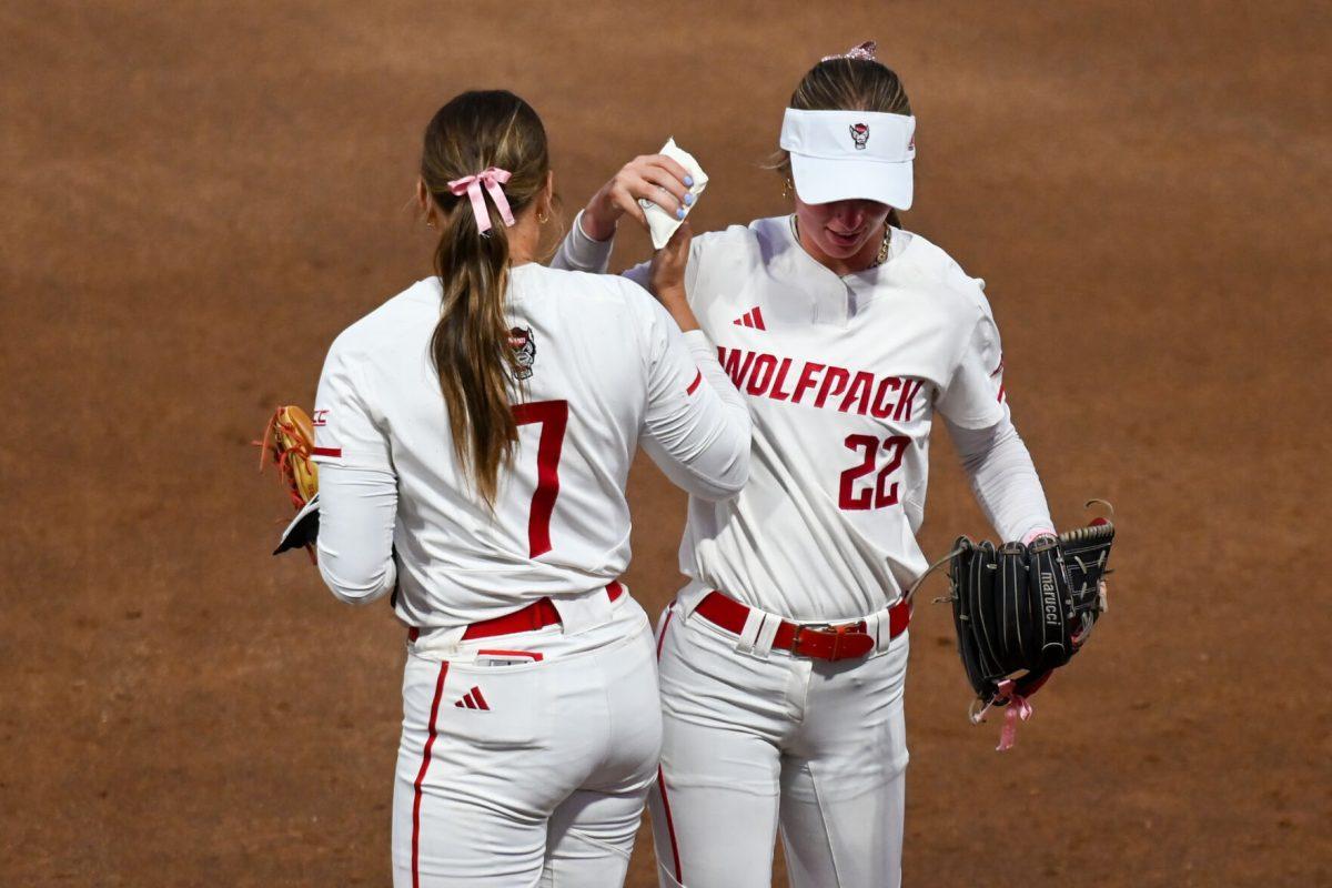 Junior pitcher Rylee Wyman (right) bumps hips with junior pitcher Wynne Gore (left) as Gore enters the game against Virginia Tech at Dail Softball Stadium on Friday, April 5, 2025. The Wolfpack lost to the Hokies 10-2.