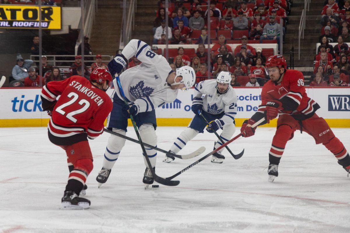Center Logan Stankoven hits a Toronto player during the game versus the Toronto Maple Leafs at the Lenovo Center on Sunday, April 13, 2025. The Hurricanes lost to the Maple Leafs 4-1.