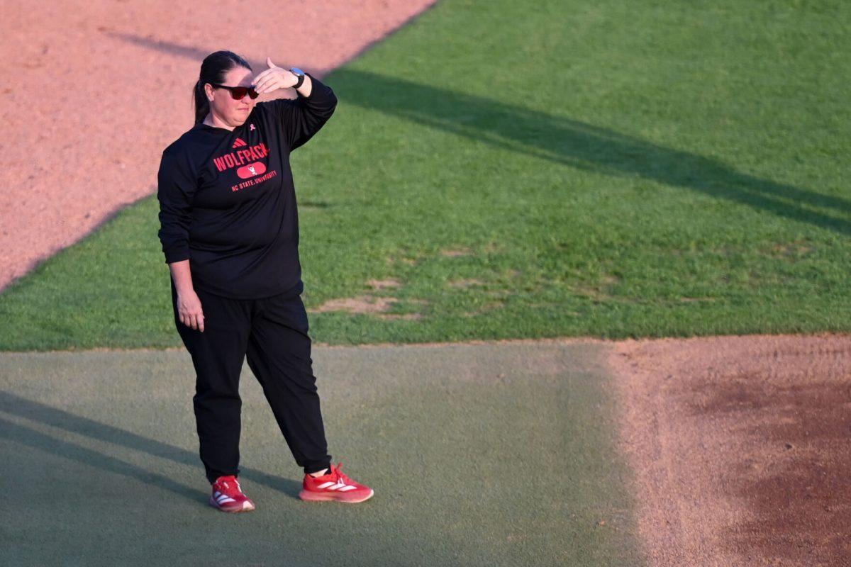 Head coach Lindsay Leftwich eyes the action of the game against Virginia Tech at Dail Softball Stadium on Friday, April 5, 2025. NC State lost the game 10-2.