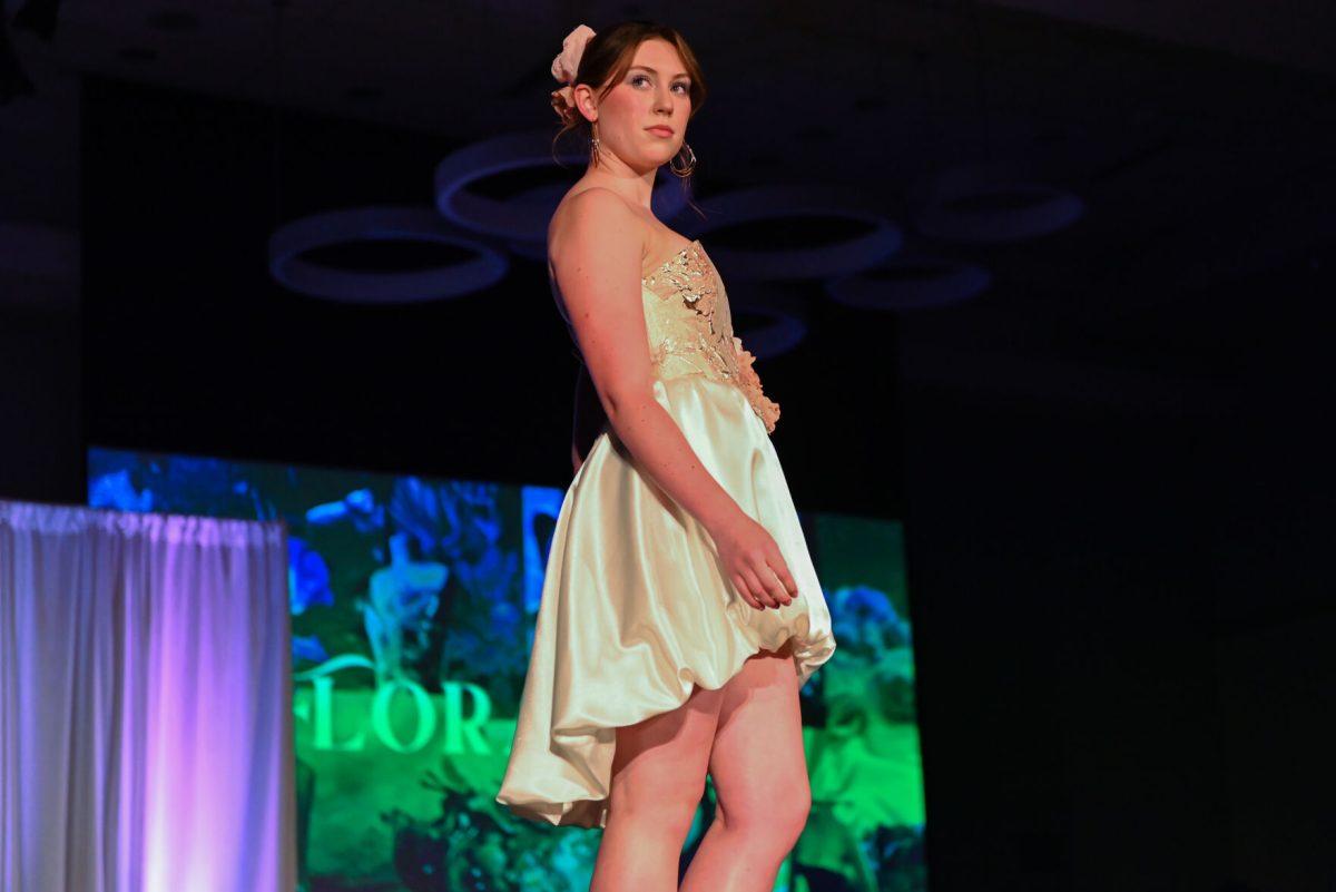 A model poses at the end of the runway wearing a piece from "Floraison," a collection designed by Brianna Anderson, a second-year studying fashion and textile design, during the 27th Annual Fashion Expose at Talley Student Union on Thursday, April 10, 2025. Anderson, one of the winning novice designers, drew inspiration from florals and spring.