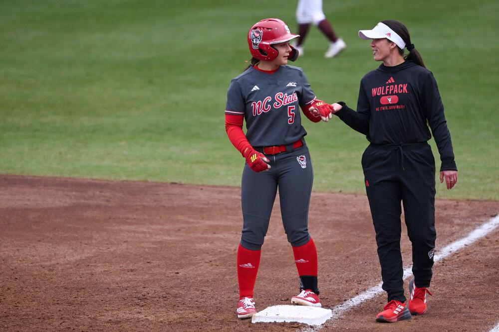 Freshman infielder Kendall Simmers high-fives assistant coach Grayson Radcliffe during the game against Central Michigan at Dail Softball Stadium on Saturday, Feb. 22, 2025. NC State won the game 6-5.