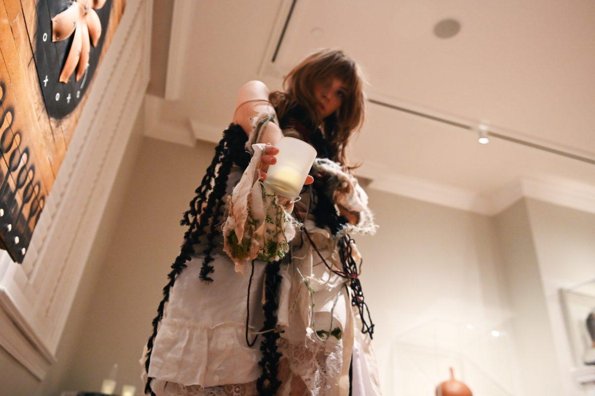 Alyx Hucks, a fourth-year studying sociology and graphic and experience design, holds out a candle while performing her design "'Til Mourning Comes" during the Art2Wear: Revive! show at the Gregg Museum of Art and Design on Thursday, April 24, 2025. Hucks&#8217; crocheted piece follows the transformation of a mortal overtaken by a banshee, and is dedicated to her grandmother.