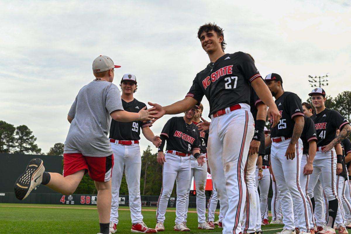 Sophomore infielder Cris McHugh high fives a kind while the kids run the bases after the game against Virginia on April 6, 2025 at Doak Field at Dail Park. McHugh aquired one walk. NC State beat Virginia 9-8.