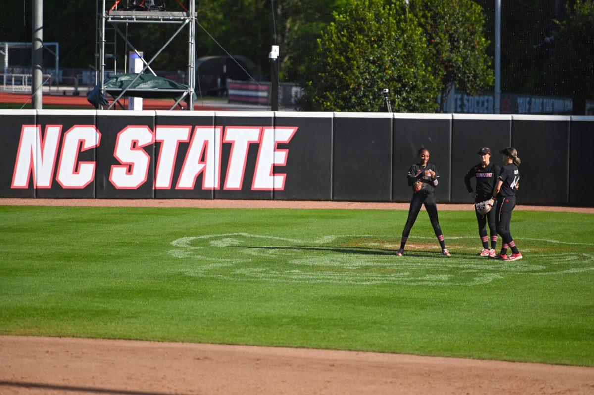 NC State outfielders talk in center field during the first game of the doubleheader against Longwood at Dail Softball Stadium on Tuesday, April 15, 2025. NC State lost the game 1-0.