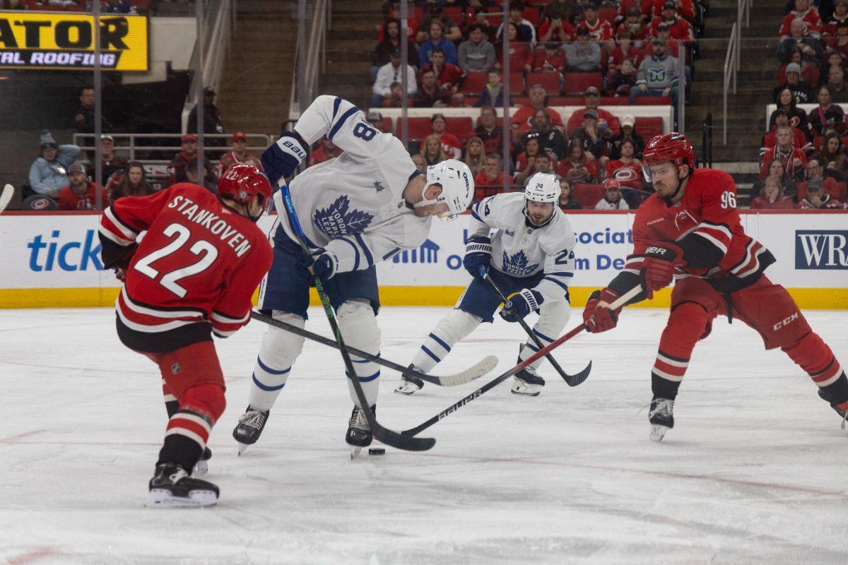 Center Logan Stankoven hits a Toronto player during the game versus the Toronto Maple Leafs at the Lenovo Center on Sunday, April 13, 2025. The Hurricanes lost to the Maple Leafs 4-1.