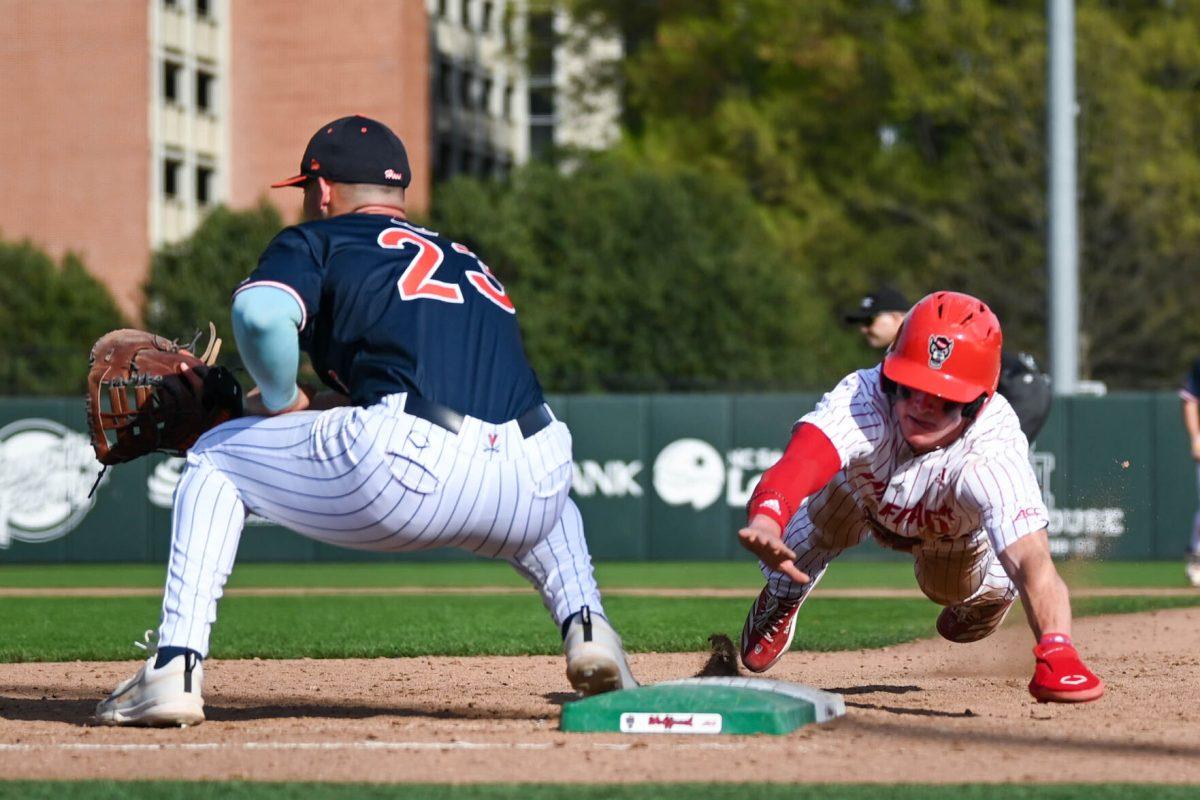Sophomore infielder Luke Nixon dives back onto first base during the game against Virginia at Doak Field at Dail Park on Saturday, April 5, 2025. The Wolfpack beat the Cavaliers 9-2.