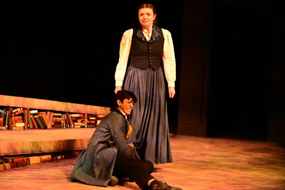 Aadee Chheda, as Laurie, holds on to the leg of Zoe Wright, as Jo, during the dress rehearsal performance of "You on the Moors" at Frank Thompson Hall on Wednesday, April 2, 2025. "You on the Moors Now" reimagines classic literary heroines as they explore themes of love, betrayal and independence.