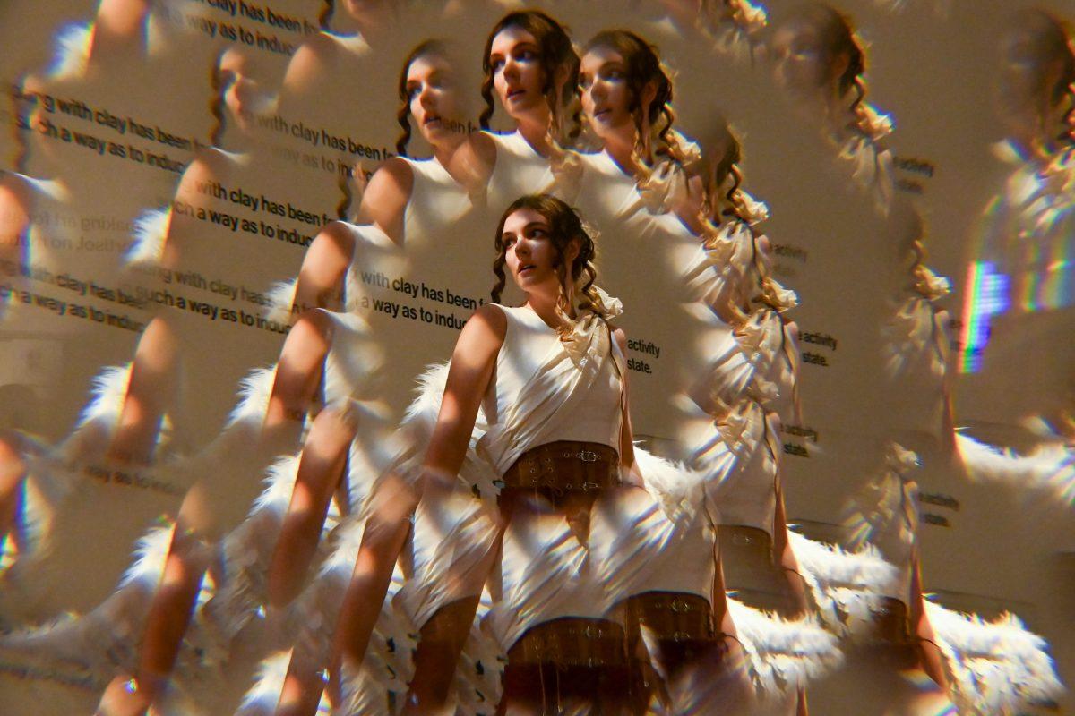 Lauren Nance, a second-year studying fashion and textile management, models Mia Potter and Devyn Williams' piece from The Fall of Icarus during Art2Wear: Revive at the Gregg Museum of Art &amp; Design on Thursday, April 24, 2025. Instead of a traditional fashion runway, Art2Wear displayed the wearable artwork through performance art done by the artists and models.