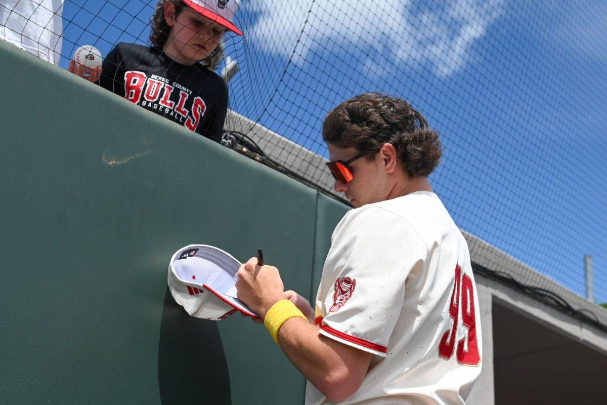 Freshman left-handed pitcher Tristan Potts signs a hat for a young fan before the game against Clemson at Doak Field at Dail Park on Saturday, April 26, 2025. NC State beat Clemson 4-1.
