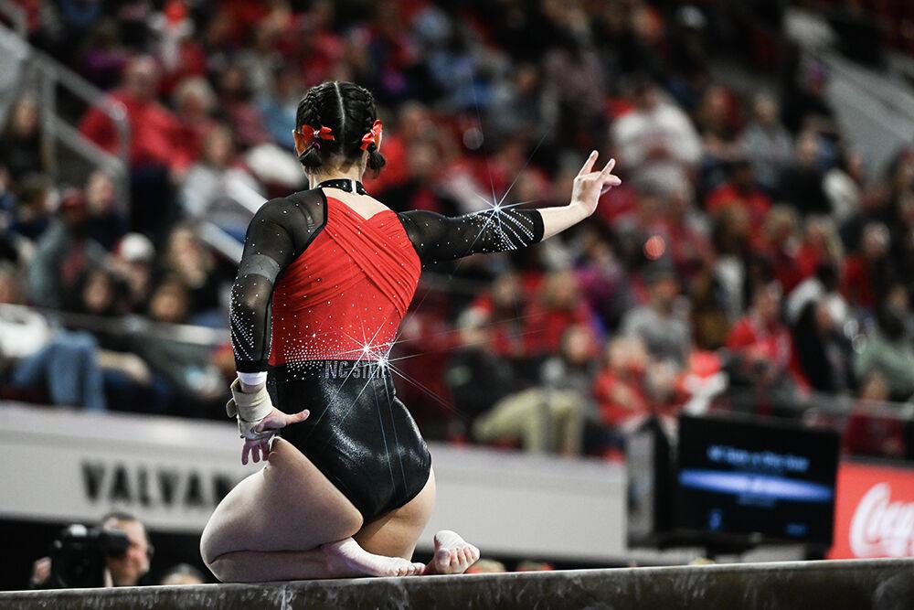 Senior Chloe Negrete holds up a wolfie during the meet against Ohio State in Reynolds Coliseum on Friday, March 7, 2025. Negrete scored 9.975 on the balance beam. NC State defeated Ohio 197.000-196.325.
