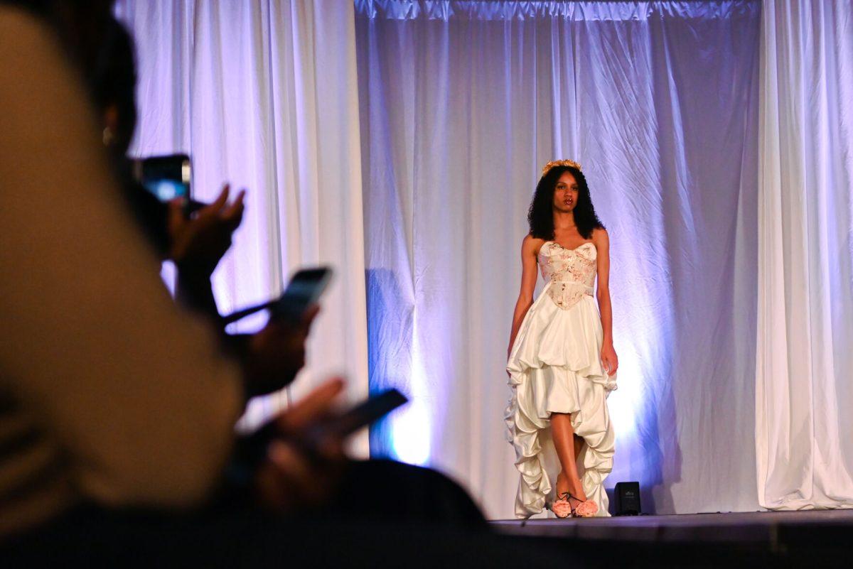 A model struts down the runway wearing a piece from "Floraison," a collection designed by Brianna Anderson, a second-year studying fashion and textile design, during the 27th Annual Fashion Expose at Talley Student Union on Thursday, April 10, 2025. The event was hosted by the NC State Wilson College of Textiles African American Textile Society.