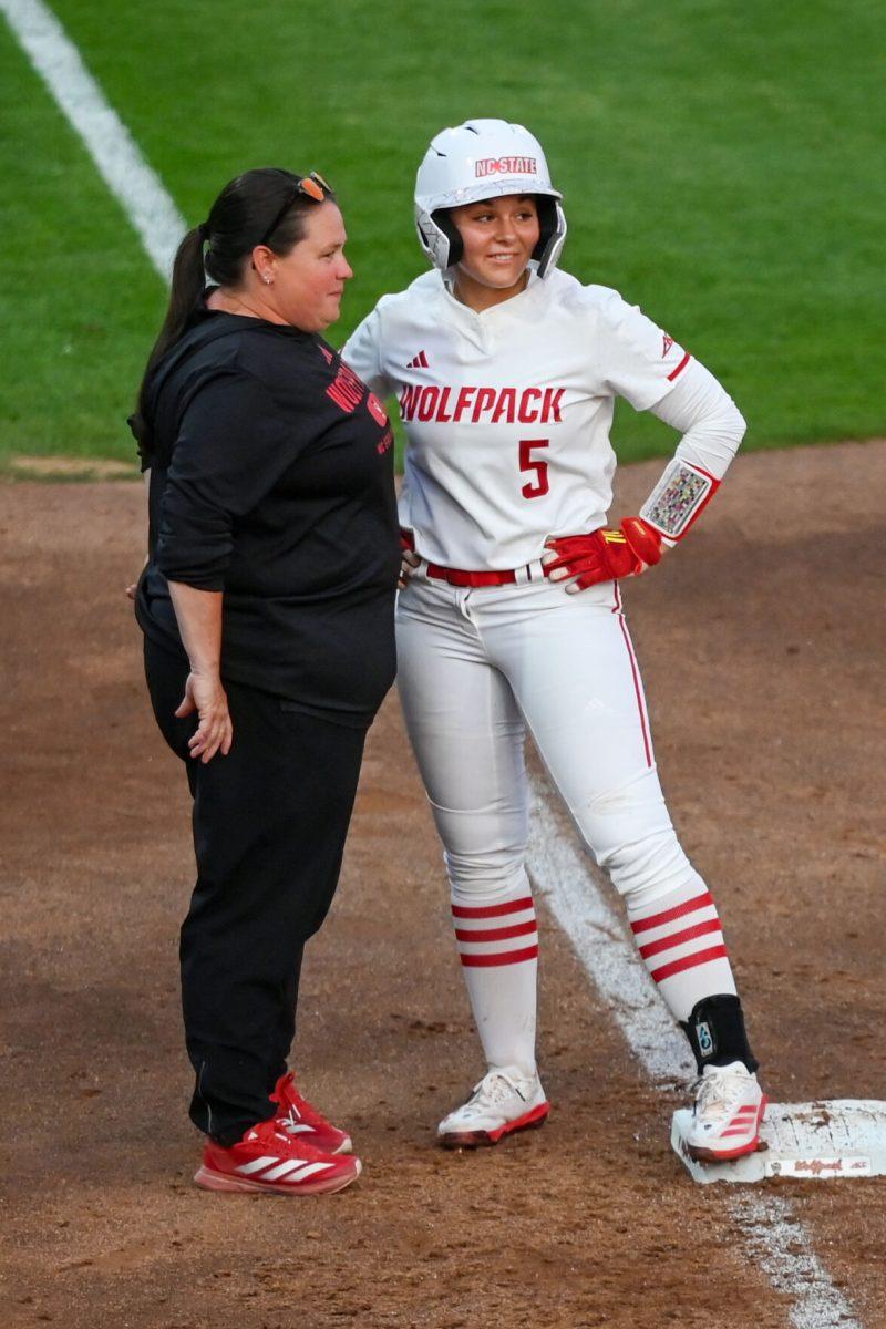 Freshman infielder Kendall Simmers speaks to head coach Lindsay Leftwich during the game against Virginia Tech at Dail Softball Stadium on Friday, April 5, 2025. Simmers hit a homreun. The Wolfpack lost to the Hokies 10-2.