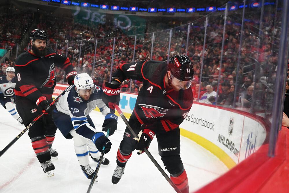 Defensemen Jaccob Slavin and Brent Burns battle an opponent for the puck during the game versus the Winnipeg Jets at the Lenovo Center on Sunday, March 9, 2025. The Hurricanes beat the Jets 4-2.