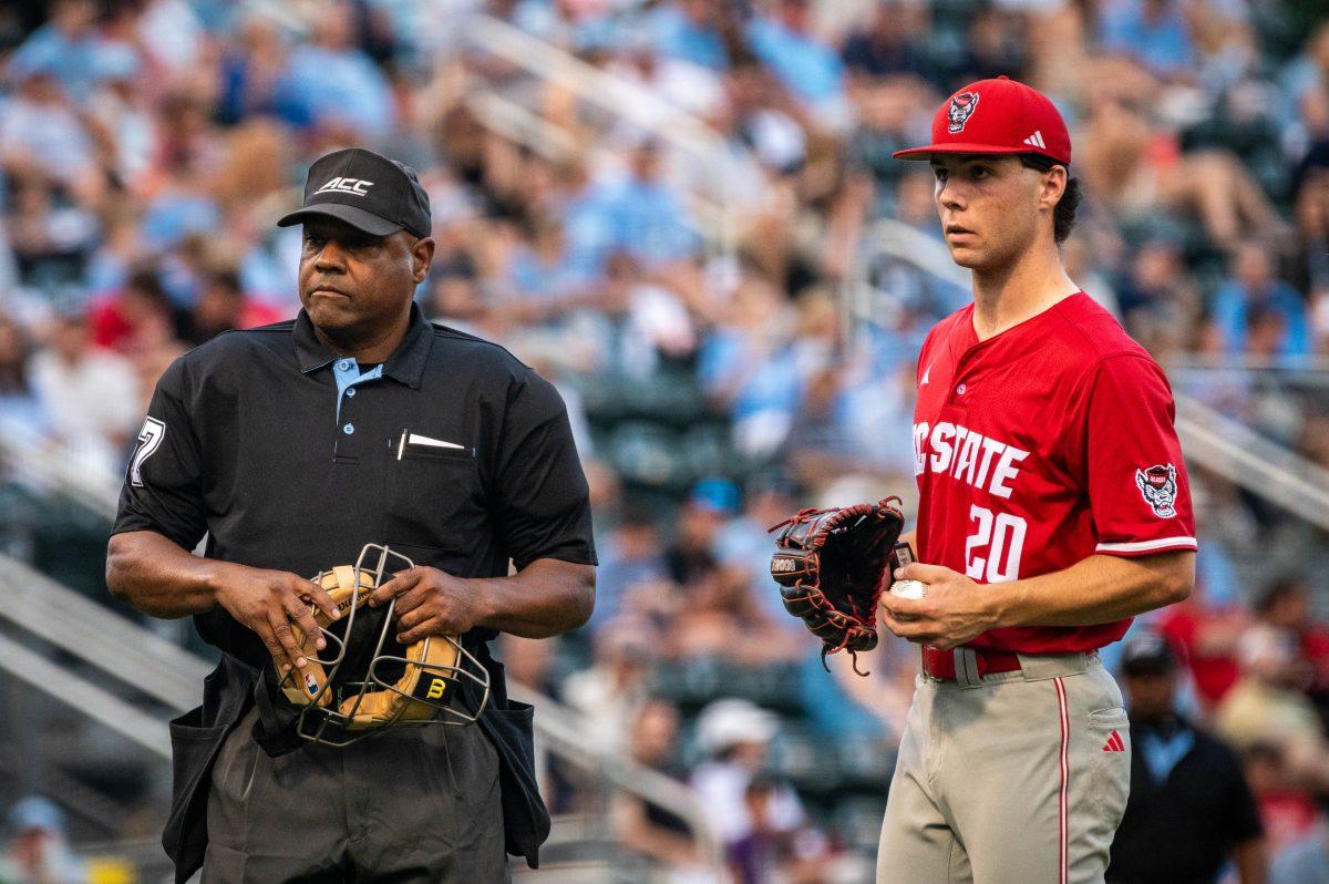 Home plate umpire Greg Street and sophomore right-handed pitcher Ryan Marohn look into the dugout after communication issues during the game against UNC in Boshamer Stadium on Thursday, May 8, 2025. The Tar Heels beat the Wolfpack 8-1.