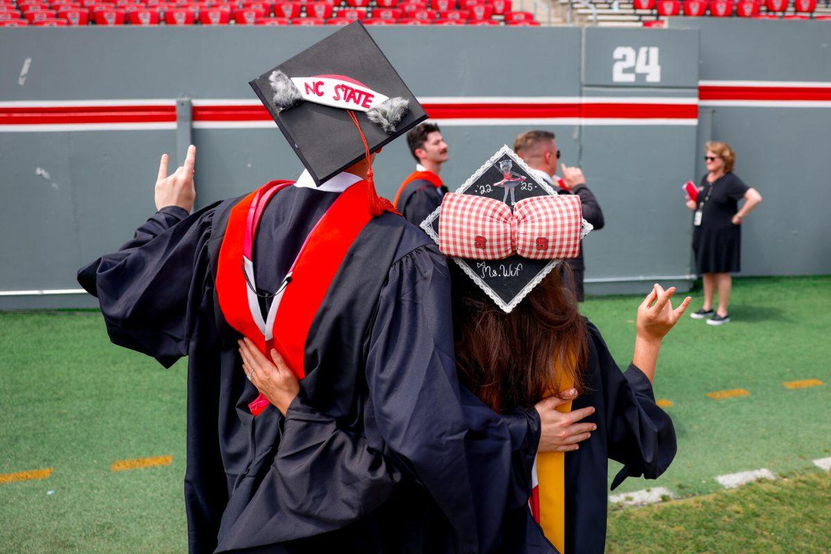 Chase Smith "Mr.Wuf", biomanufacturing masters graduate, and Savana Stone "Mrs.Wuf" hold up the "wolfie" hand signs after the University Commencement ceremony in Carter-Finley Stadium on Saturday, May 3, 2025. Over 1,783 students graduated with Master's degrees at NC States 2025 Spring Commencement Ceremony.