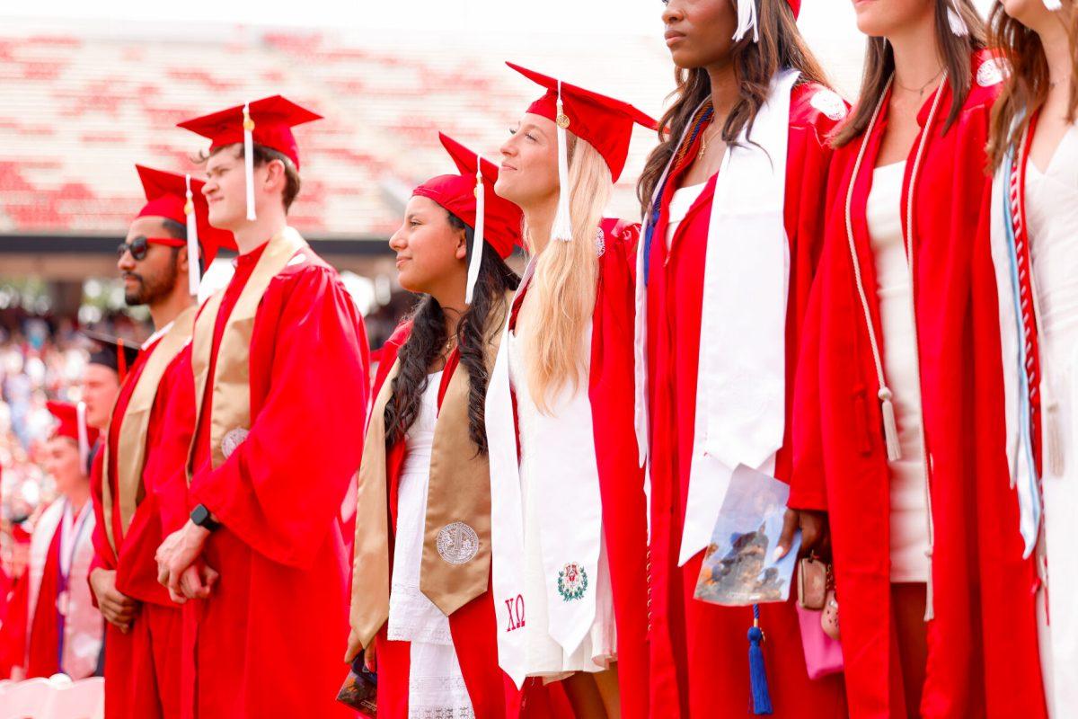 Lauren Pountnay, a criminology school graduate, locks arms with other students around her to listen to NC State's alma matter during the University Commencement ceremony in Carter-Finley Stadium on Saturday, May 3, 2025. Over 5,079 students graduated with Bachelor's degrees at NC States 2025 Spring Commencement Ceremony.