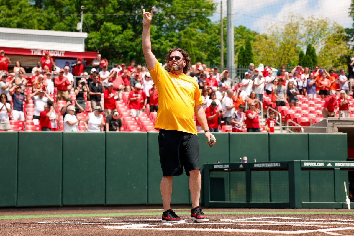 Former American Idol contestant Adam Lee Decker holds up the "wolfie" sign before the 2nd annual "Victory over Cancer" game at Doak Field at Dail Park on Sunday, April, 27, 2025. The game raised 55,000 so far for funding for Pediatric research. NC State beat Clemson 4-1.