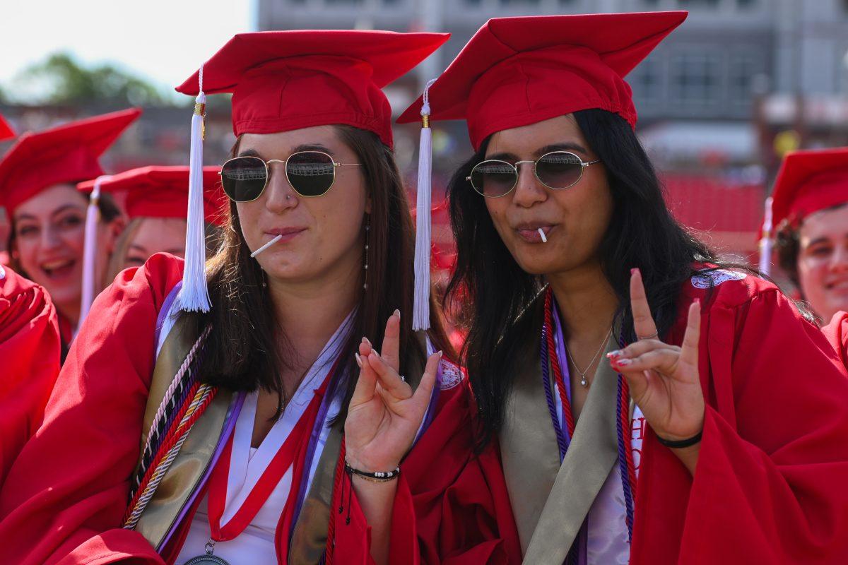Christina Ross, graduating with a bachelor's degree in biology with a concentration in human biology, and Ishita Saxena, graduating with bachelor's degree in biological science with a concentration in integrative physiology and neurobiology, eat lollipops during the Spring Commencement Ceremony at Carter-Finley Stadium on May 3, 2025. NC State awarded more than 5,000 bachelor's degrees.