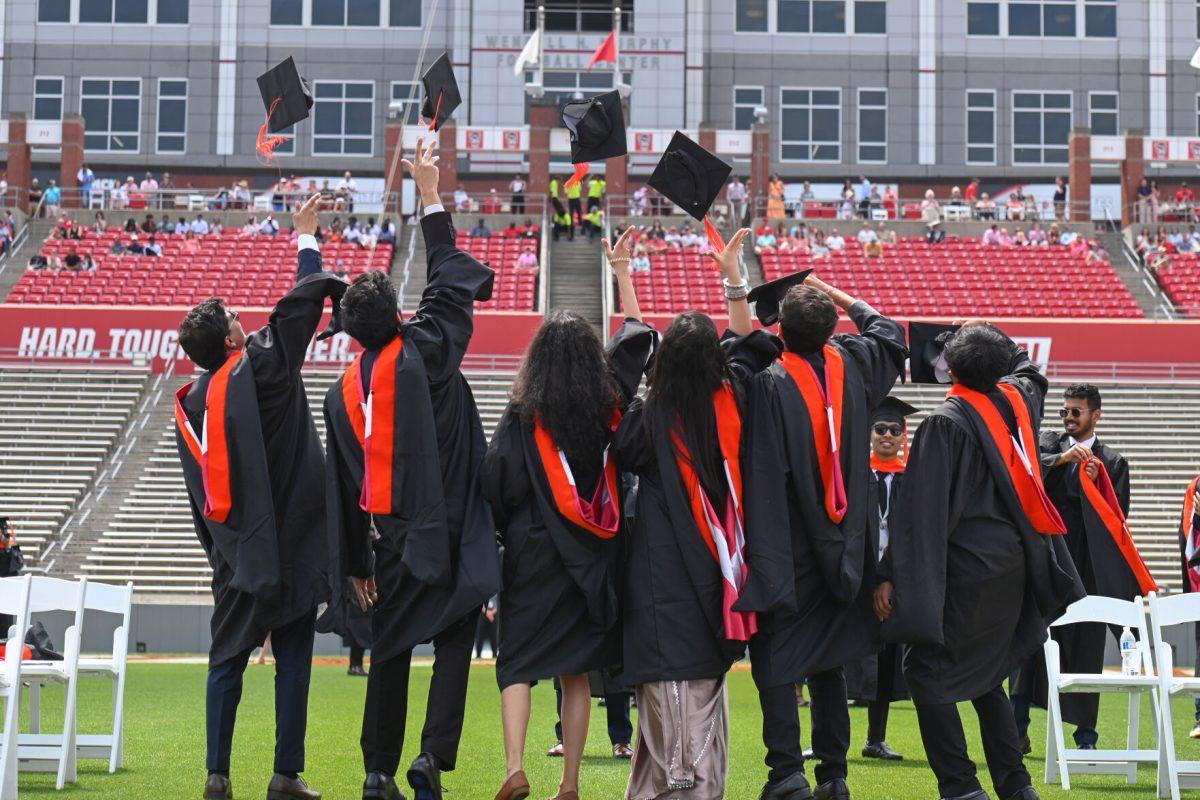 A group of graduates receiving master's degrees take photos while throwing their caps during the Spring Commencement Ceremony at Carter-Finley Stadium on May 3, 2025. The spring 2025 graduating class included 828 international students.