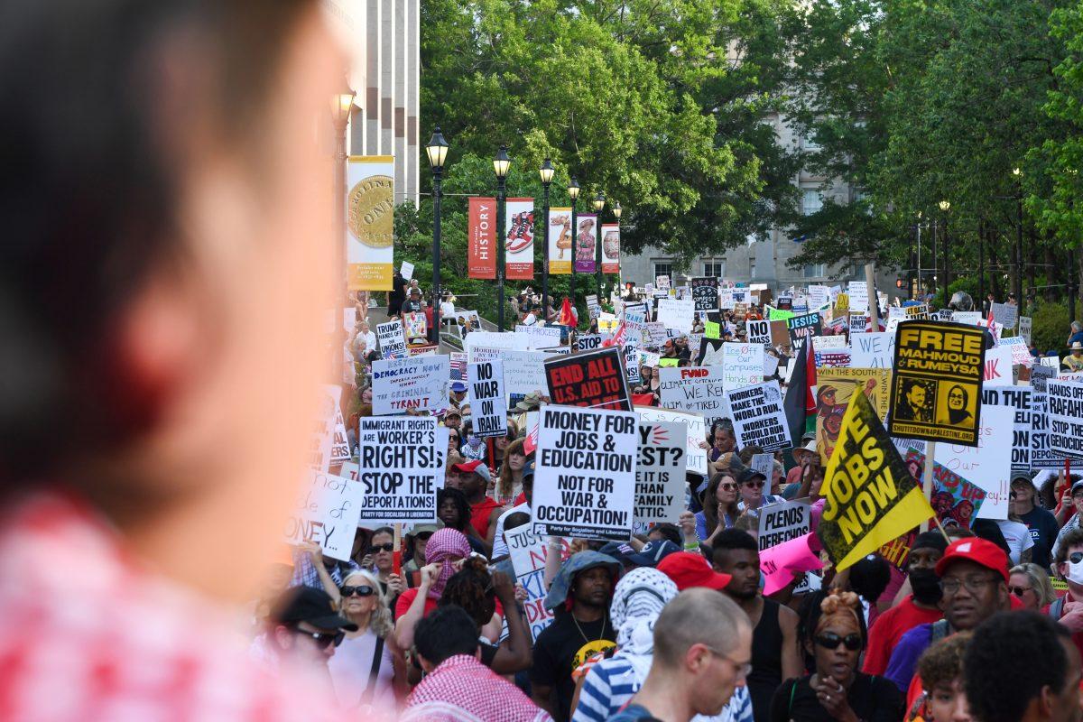 An event organizer looks onto demonstrators piling in to hear guest speakers after the Raleigh May Day march at Bicentennial Plaza on Thursday, May 1st., 2025.