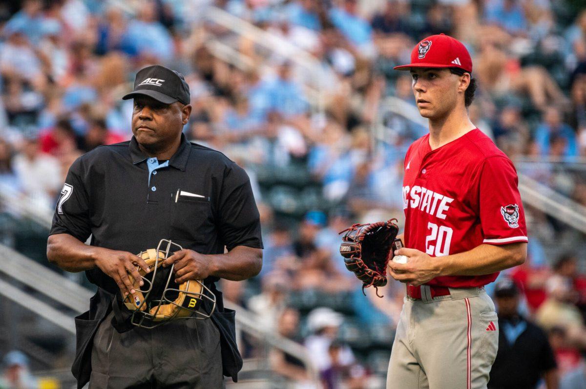 Home plate umpire Greg Street and sophomore right-handed pitcher Ryan Marohn look into the dugout after communication issues during the game against UNC in Boshamer Stadium on Thursday, May 8, 2025. The Tar Heels beat the Wolfpack 8-1.